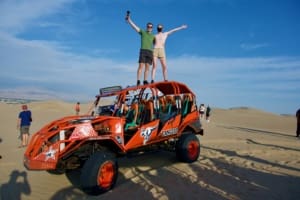 Us standing atop a 4-wheel drive in Huacachina, Peru